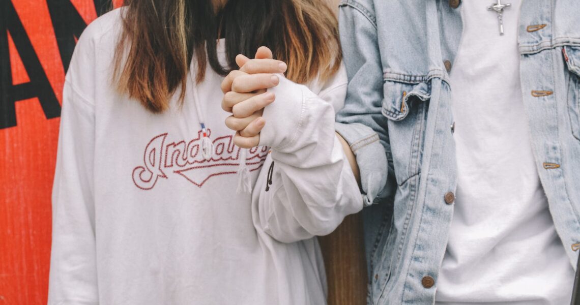 Woman Holding Man's Hand During Day