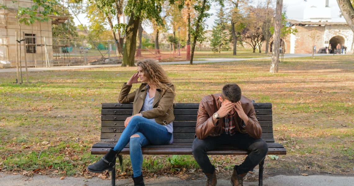Woman And Man Sitting on Brown Wooden Bench