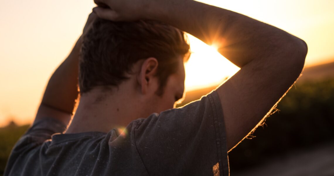 man holding his hair against sunlight